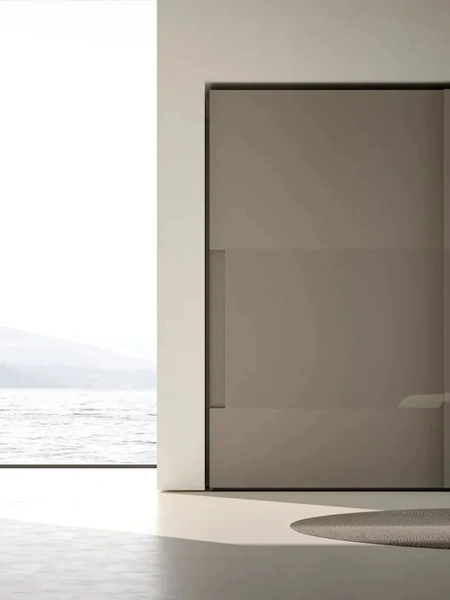 Armadio Atelier con ante scorrevoli con maniglia integrata in melaminico Fango e inserti in vetro Shine di Adok