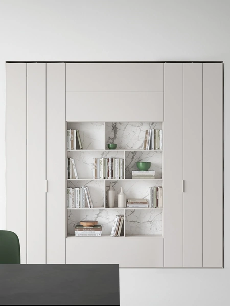 Libreria in nicchia in laccato bianco opaco con schiena del vano a giorno in gres porcellanato effetto marmo di Caccaro